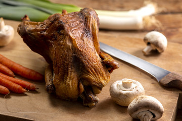 Crispy roasted chicken and leeks, carrots and mushrooms, on a chopping board.