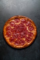 Italian pizza with pepperoni cheese and sauce on black background