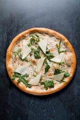 Italian pizza with cheese arugula vegetables on black background top