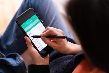 Top view of unrecognizable woman doing online shopping from the house. Groceries application to buy food and stay home during pandemic time. Social distance and coronavirus covid - 19 concept.