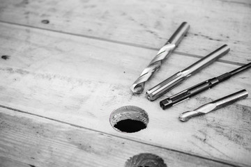 Carbide drills are laid on wood floors in black and white tones. - obrazy, fototapety, plakaty