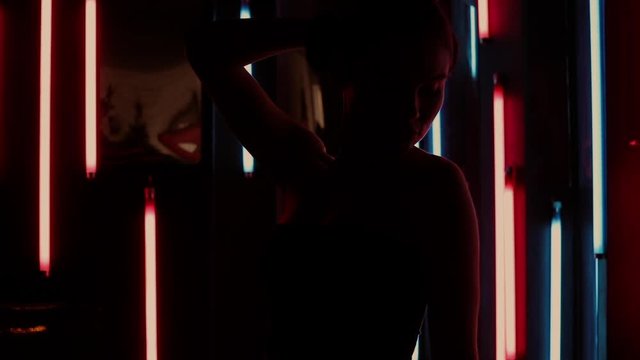 Sensual woman under neon illumination