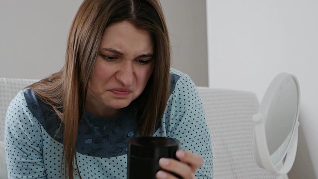 The girl looks in the mirror, the skin is not happy faces. Allergy to cosmetics, fear of aging, circles under the eyes, wrinkles. Low self-esteem, dysmorphic disorder