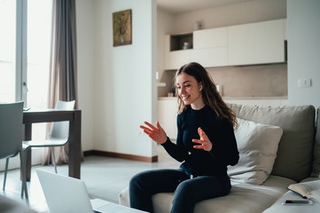 Obraz premium Giovane bella ragazza studente/ lavoratrice studia/ lavora da casa con il computer. Smart working e distanza sociale. Lavorare con la tecnologia 