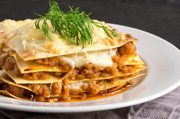 Meat lasagna on a wooden background.