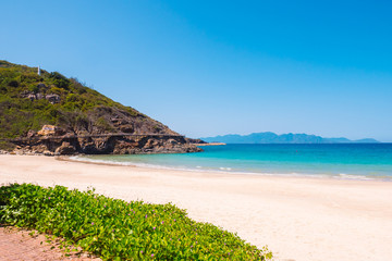 Tropical beach near ocean with rocky island