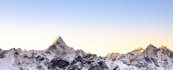 Himalayan mountain range. Banner sized photo with Ama Dablam peak and blue sky. - obrazy, fototapety, plakaty