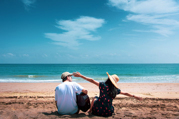 Couple singing and playing guitar buy the beach