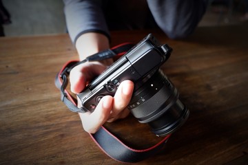A Man Holding a Camera on the Table

