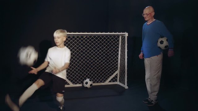 Footballer Grandson Is Showing Grandfather His Soccer Skills With Ball