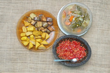 Indonesian traditional food, chilli paste, sour soup, fried eggplant and tofu.