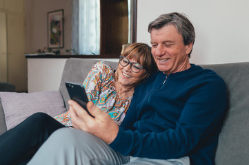 Coppia di europei di mezza età realizza una video chiamata con la famiglia. Tablet, laptop, smartphone. Distanza sociale e tecnologia 