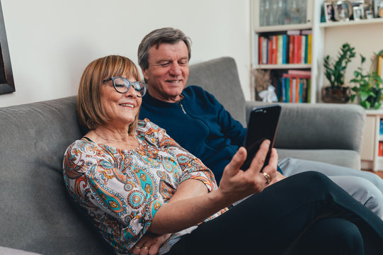 Coppia di europei di mezza et&agrave; realizza una video chiamata con la famiglia. Tablet, laptop, smartphone. Distanza sociale e tecnologia 