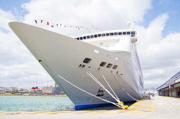 Cruise ship or cruiseship liner in port of Piraeus of Athens, Greece with city skyline and...