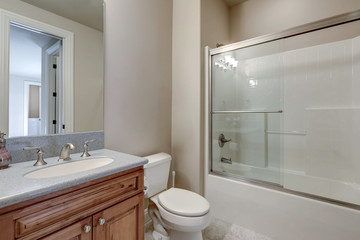 Budget American bathroom new interior with classic design of tub and walk in shower combination.