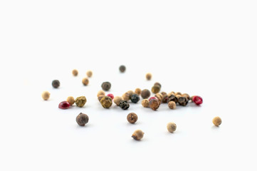 Red, green and black peppercorns or balls mixed isolated on a white background.