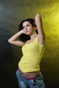 Beautiful young girl on yellow. Brunette in a yellow tank top.