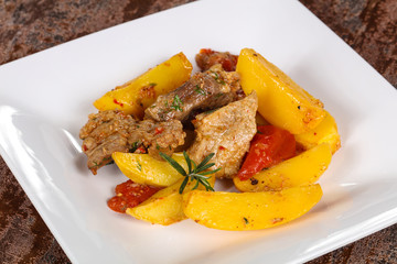 Baked pork meat with potao and tomato