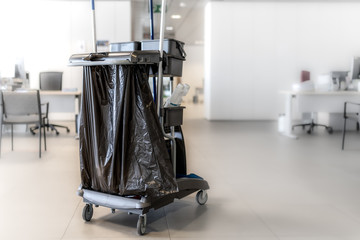 Vista trasera. Carro de limpieza en una iluminada oficina blanca. Desinfeccion