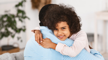 Grandparent grandchild closeness. Curly African American girl embracing her grandpa indoors. Panorama