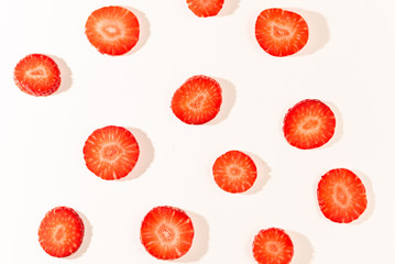 ripe, fresh, natural red cut strawberries pieces forming pattern, a healthy spring and summer fruit, on white background