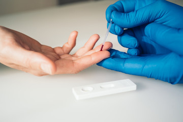 Close-up shot of a doctor doing a rapid test for the detection of Covid-19 on white background....