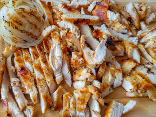 Grilled chicken finely chopped and whole sliced ​​onion grilled on a wooden board. Home made to be put into a doner kebab. 