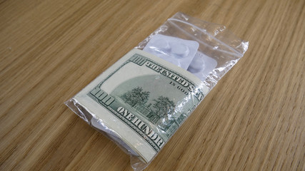 Pills in a plastic bag with dollars