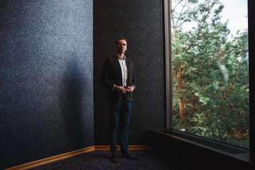 Confident well-dressed man in luxury apartment interior.