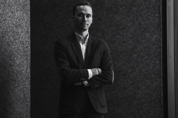 Confident well-dressed man in luxury apartment interior.