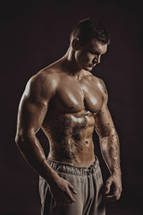 Fototapeta na wymiar Studio portrait of a shirtless athletic tattooed male.