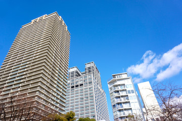 Obraz premium Osaka, Japan-January 18, 2019 : Landscape of city building on bright blue sky with clouds background.