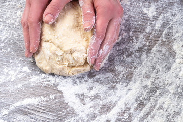 Woman hands kneading dough on the table