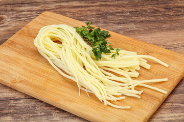 Chechil spaghetti cheese over board