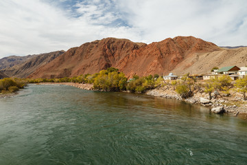 Fototapeta na wymiar Kokemeren river, houses by the river in the village of Aral, Jumgal district of Naryn region in Kyrgyzstan.