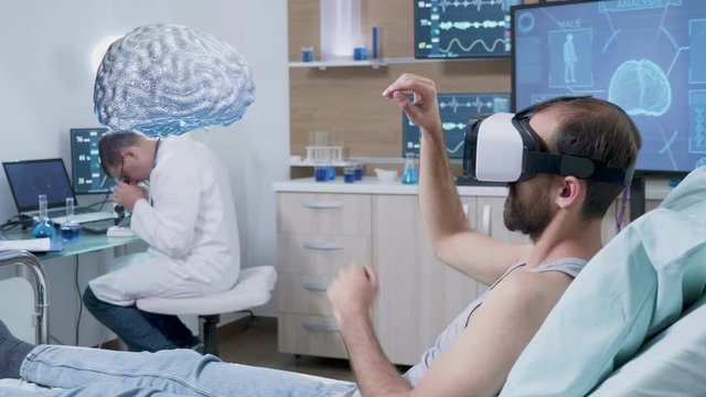 Patient wearing VR headset looking at brain scan in AR hologram in front of him