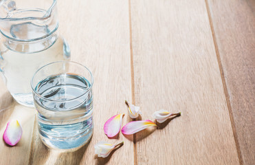 Water glass with glass jar on wooden table. Glass and clean drinking water with copy space.