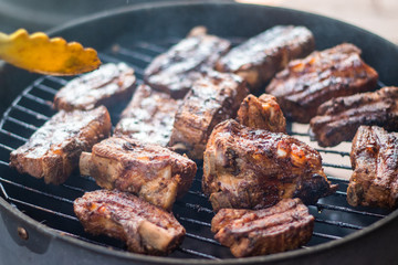 Detail of  BBQ pork ribs grilling on home smokehouse