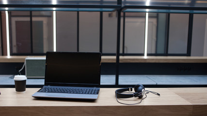 Workplace with a laptop, Notepad and pen, in the distance are headphones and a cardboard