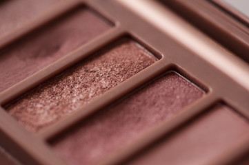 Eye shadow palette with rose gold glitter tones closeup. Beauty products. Selective focus.