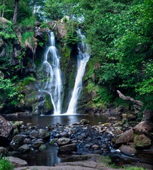 Waterfall in green forest at summer time.