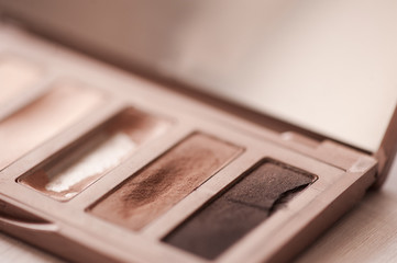 Used eye shadows in pastel brown matte tones closeup. Beauty products. Selective focus.