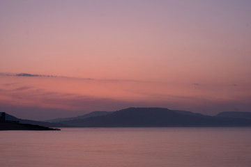 sunrise over water and hills