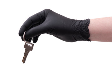 Hand in black leather glove with key isolated on white background