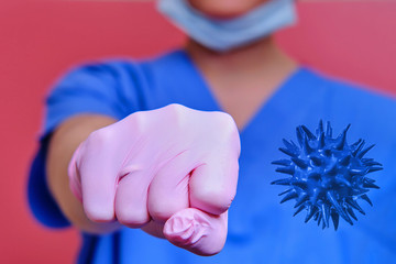 A doctor in medical gloves punches the virus, close-up. Concept of ending the coronavirus pandemic and lifting the quarantine - stay at home