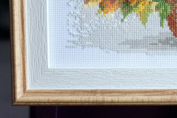 cross stitch corner on the canvas, framed