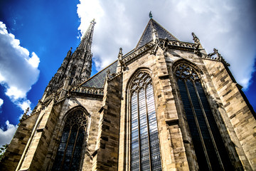 Fototapeta na wymiar St. Stephen's Cathedral towers up to a slightly cloudy blue sky. Vienna. Austria