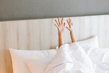 Capture of female arm stretching while waking  up on bed.