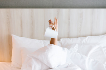 Female hand holding a cup of coffee while lying down on bed. Coffee morning concept
