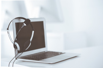 Call center and communication support, customer service help desk. VOIP headset on laptop computer